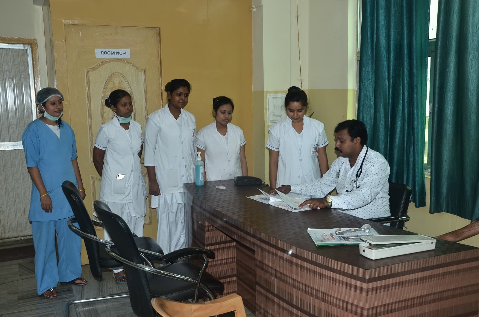 Senior doctor consulting with nursing team at IDMH in a consultation room