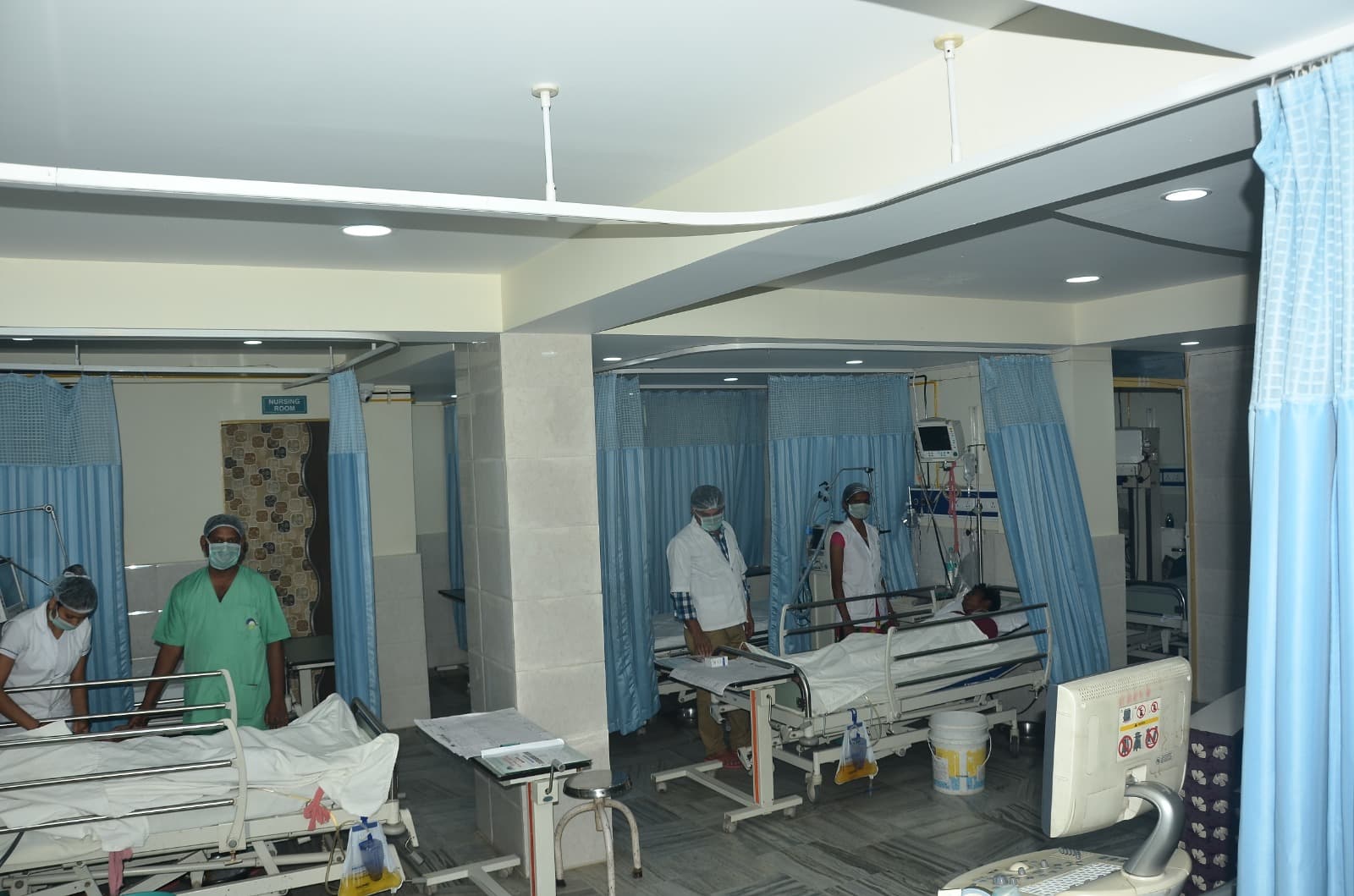 Intensive Care Unit at IDMH with multiple beds, patient monitors, and attending staff